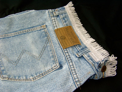 Details of fringe added to baggy jeans bagpipe cover